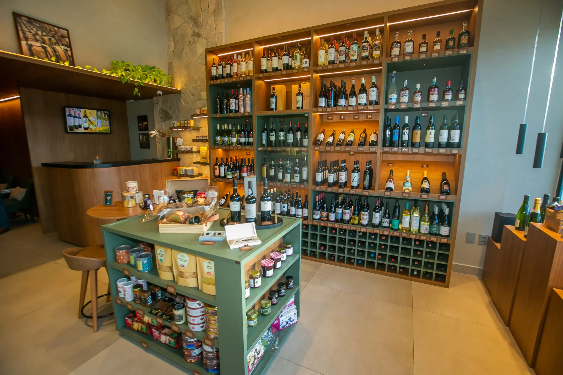 Interior da loja com prateleiras de vinho e ilha de empório